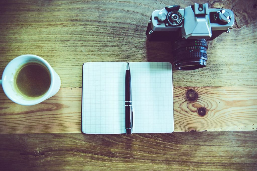 Illustrative photograph of creative desk camera notebook